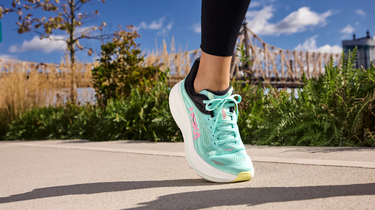 Runner’s rearfoot close-up showing padded collar and structured heel counter while tightening a gusseted tongue for secure lockdown.
