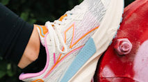 Runner stepping from wet asphalt onto packed dirt showing outsole rubber and mixed-depth lugs in action.
