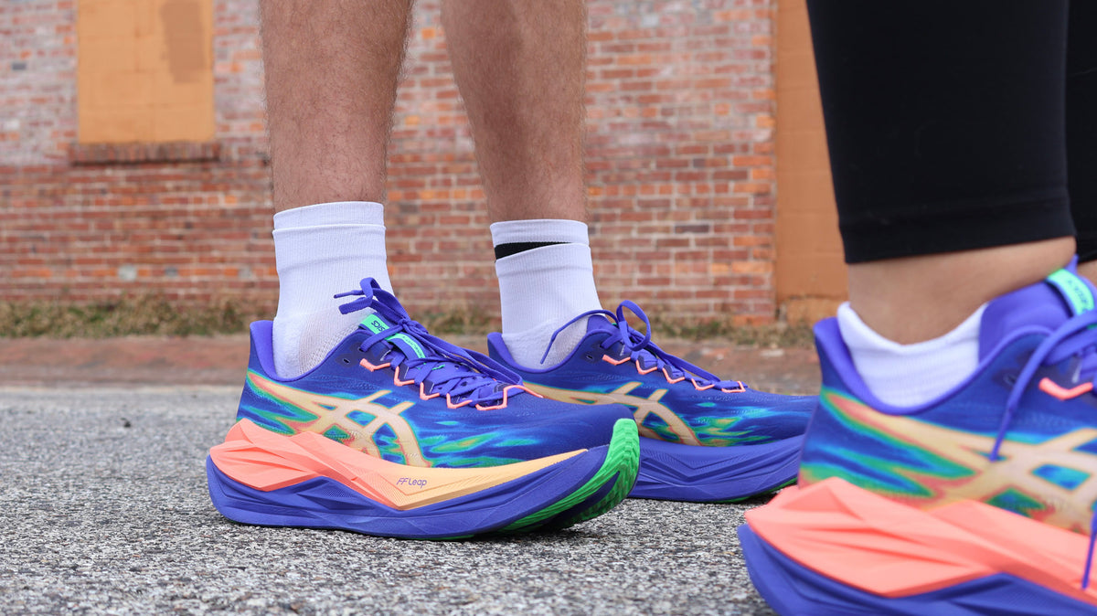 Runner holding two shoes that show different midsole foams and stack heights—one tall, soft EVA stack and one PEBA superfoam racer.