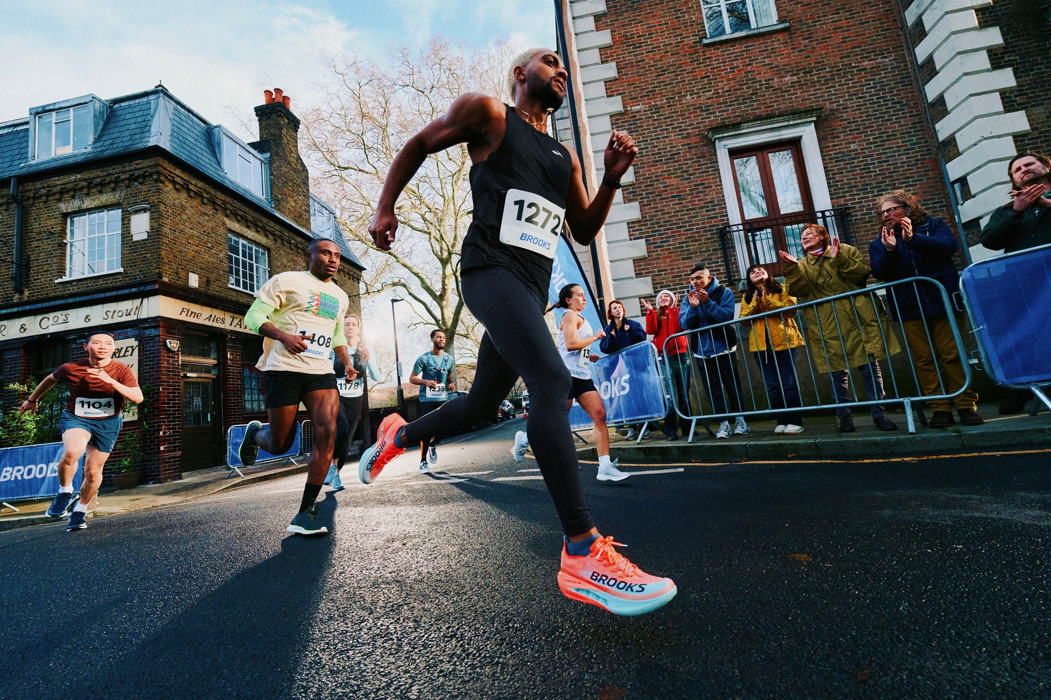 Runner lacing a plated super shoe next to a cushioned daily trainer before a tempo workout.