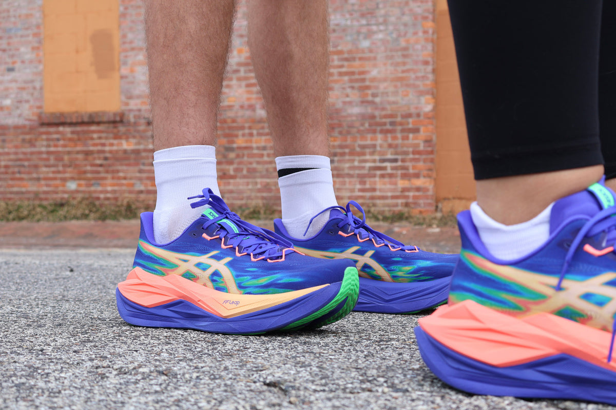 Runner holding two shoes that show different midsole foams and stack heights—one tall, soft EVA stack and one PEBA superfoam racer.