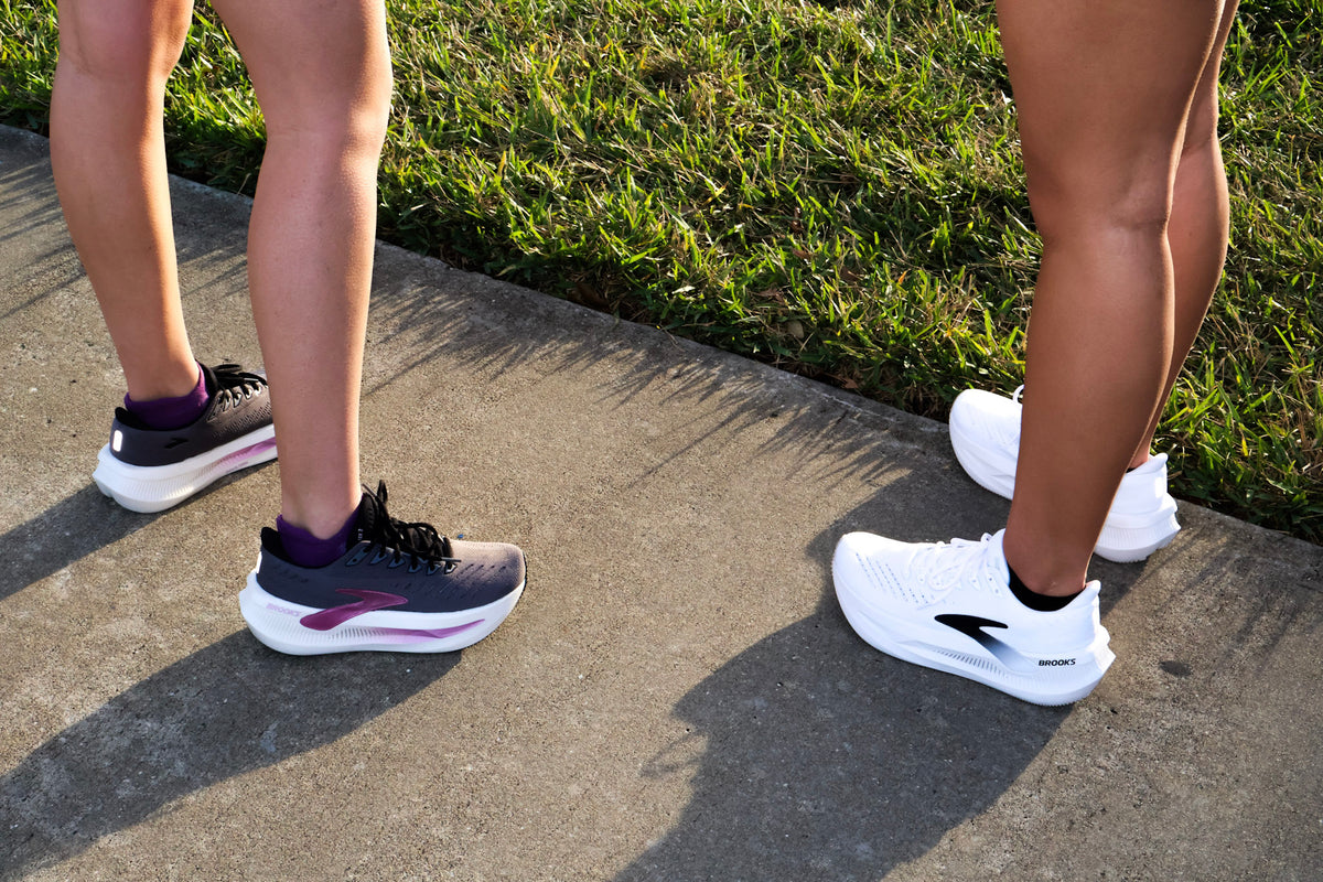 Runner lacing one high‑stack cushioned shoe and one lightweight responsive shoe side by side before a workout.