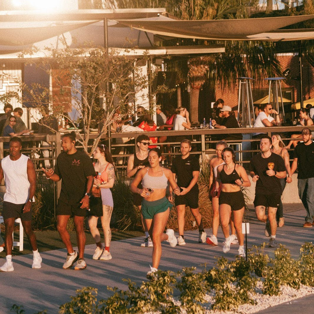 A Fit2Run run club outdoors near a building with a sign.