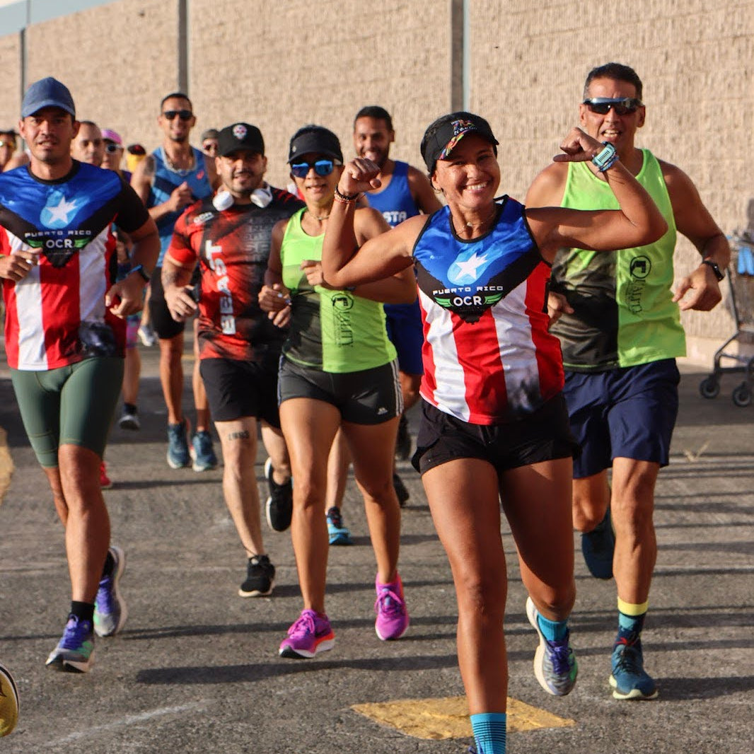 Group of runners participating in a Fit2Run race, wearing colorful outfits with visible branding.